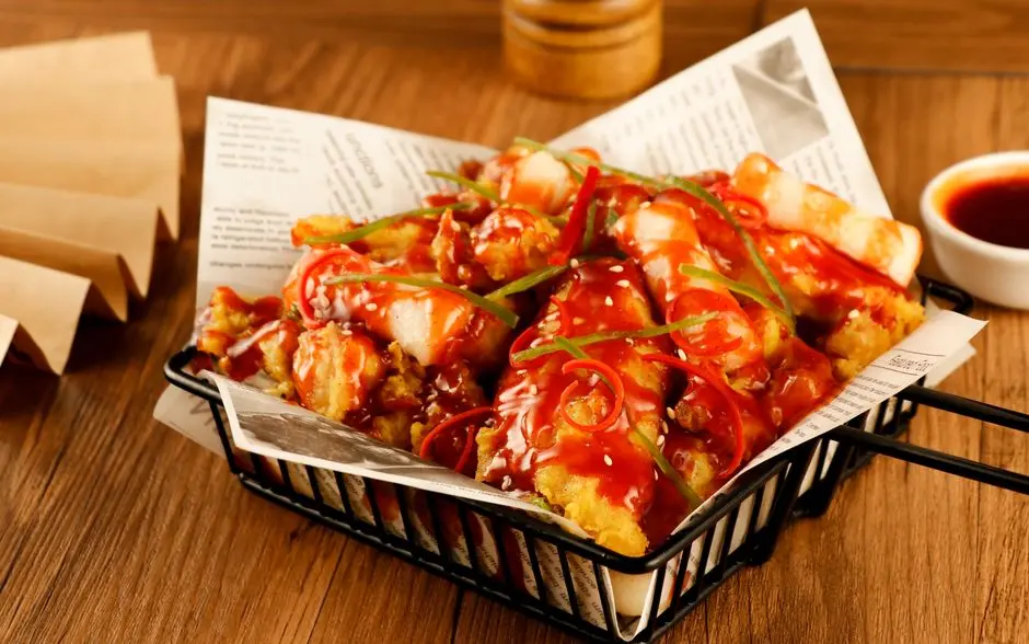 Piring berisi cireng goreng bertumpuk dengan saus sambal merah di sampingnya